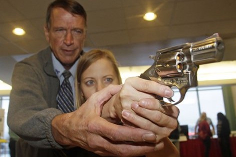 A Utah teacher learns how to fire a gun. (Credit: AP)
