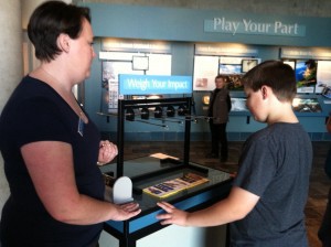 Sarah-Mae Nelson, Climate Change Interpretive Specialist at the Monterey Bay Aquarium, instructs a young visitor on the benefits of energy conservation. CREDIT: Ari Phillips