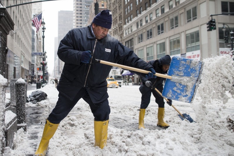 Workers clear sidewalks of snow on Fifth Avenue, Friday, Jan. 3, 2014, in New York. CREDIT: AP PHOTO/JOHN MINCHILLO