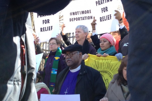 Bishop Julius C. Trimble (center) prays as he waits for police to arrest him. CREDIT: ThinkProgress/ Esther Y. Lee