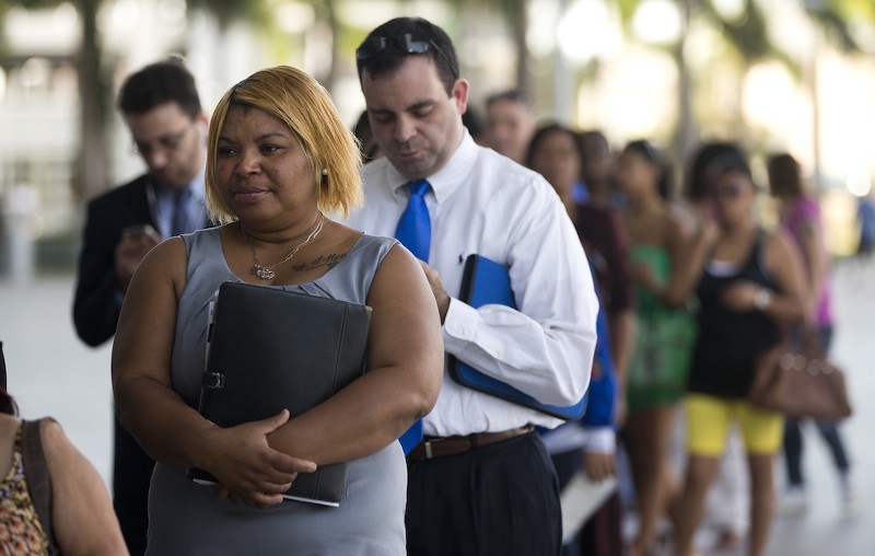 Job seekers stand in line at a job fair in Miami CREDIT: AP
