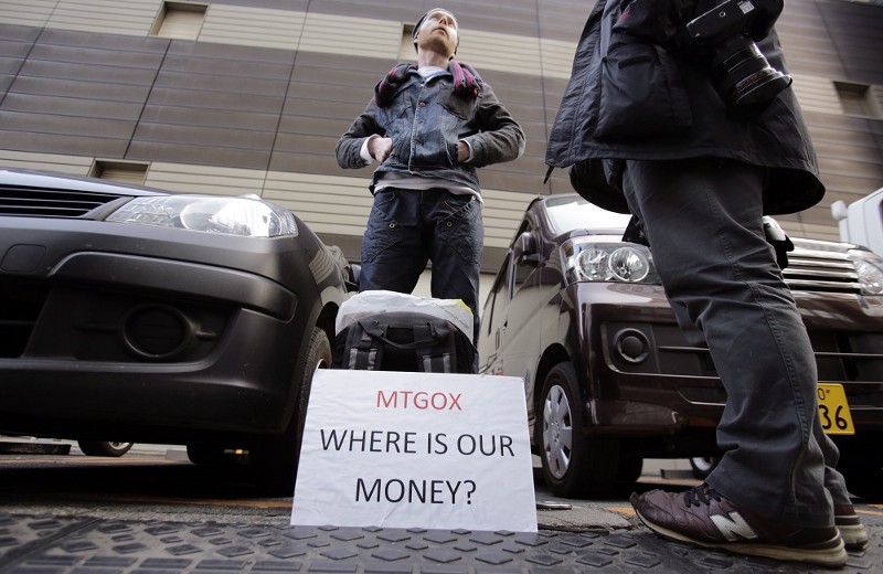 A protester stands outside of Mt Gox headquarters in Tokyo after the BitCoin banking site’s collapse. CREDIT: AP PHOTO/SHIZUO KAMBAYASHI