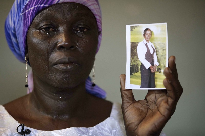 Martha Mark, the mother of kidnapped school girl Monica Mark cries as she displays her photo CREDIT: AP PHOTO/SUNDAY ALAMBA