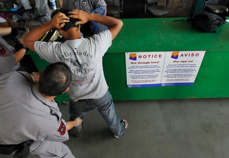 An undocumented immigrant is being processed through the Tucson Sector by a Border Patrol agent. CREDIT: ASSOCIATED PRESS/ ROSS FRANKLIN/