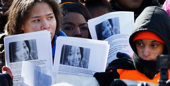 Protesters hold up photos of 15-year-old Hadiya Pendleton at the Chicago scene where she was killed earlier this year hanging out with some friends, during an anti-gun violence rally in February. CREDIT: Associated Press
