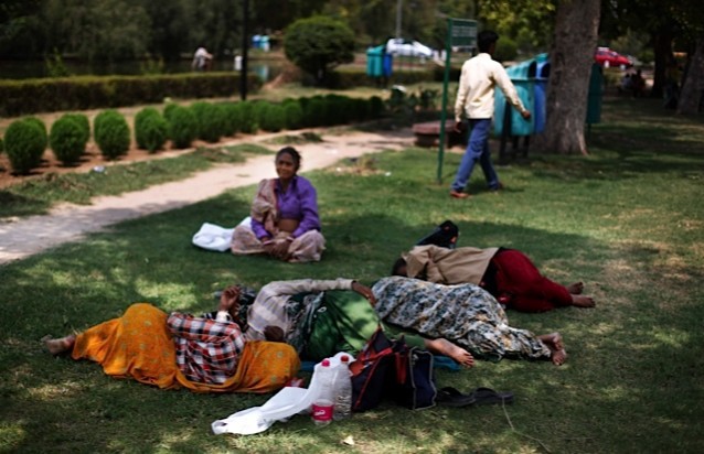Indian municipal workers sleep on the grass under the shade of trees at a public park on a hot summer afternoon in New Delhi. CREDIT: A.P. Images