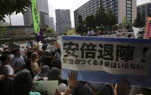 People protest outside the Japanese prime minister’s office with a banner that reads banner reads: “Abe Step Down!” CREDIT: AP Photo/Eugene Hoshiko