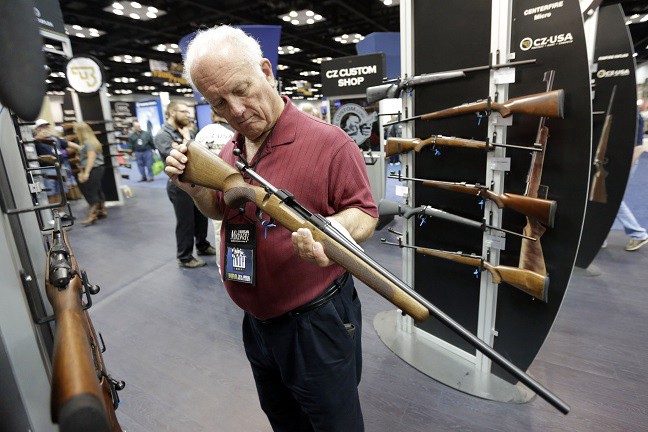 Guns on display at the NRA’s annual convention. CREDIT: AP PHOTO/AJ MAST