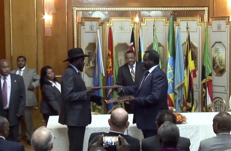 South Sudan’s President Salva Kiir, center left, and rebel leader Riek Machar, center right, exchanging signed peace treaties on May 9 CREDIT: P PHOTO/AP VIDEO