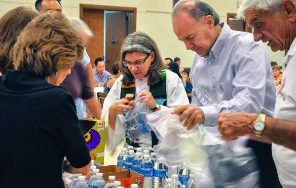 Rev. Nancy Springer helps parishioners prepare care packages for immigrants. CREDIT: Jack Jenkins