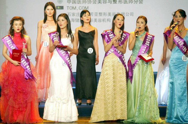 Contestants parade on stage during the final of China’s first ever beauty pageant for women who have had plastic surgery, in Beijing Saturday Dec. 18, 2004. The event was organized after an 18-year-old woman was disqualified from another Chinese beauty pageant earlier this year on the grounds that she had had cosmetic surgery. Competitors had to submit proof that they had undergone surgery. Sponsors included Chinese makers of cosmetic surgery products. The contest included a talent show and evening gown and swimsuit competitions. (AP Caption)
