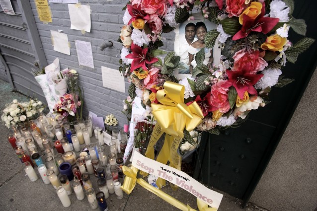 A photo of Sean Bell with his fiance Nicole Paultre and one of his children is displayed at a candlelight memorial at the scene of his shooting. CREDIT: P Photo/Adam Rountree