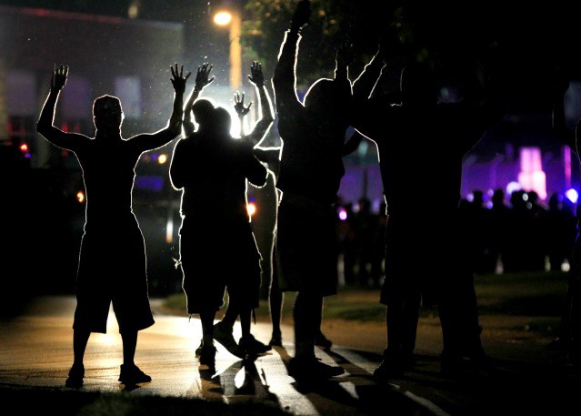 Protesters in Ferguson, Missouri raise their hands in the middle of the street after the police shooting death of Michael Brown CREDIT: AP PHOTO/JEFF ROBERSON