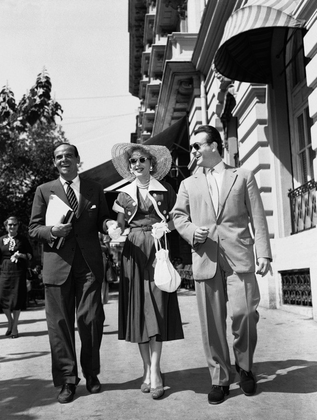 Christine Jorgenson, center, the former GI who claims to have become a woman, with Marc Lawrence, tough guy actor and Greek actor, George Bivides husband of Kerima, a Italian actress, walk down fashionable Via Veneto in Rome, Sept. 11, 1954. (AP Caption) CREDIT: AP Photo/Jim Pringle