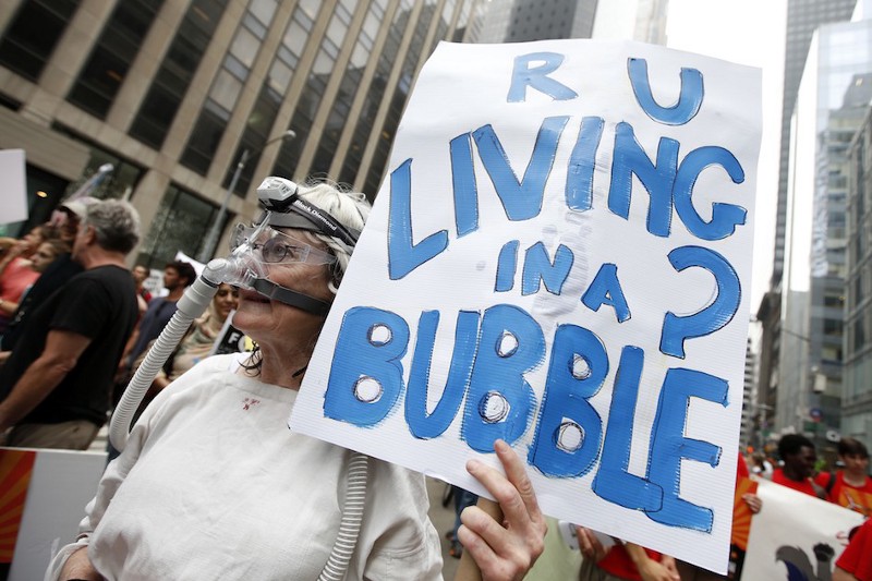 A demonstrator holds a sign at the People’s Climate March in New York City, Sunday, September. 21, 2014. CREDIT: AP PHOTO / JASON DECROW