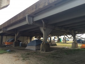 A homeless encampment under a highway. CREDIT: Kira Lerner