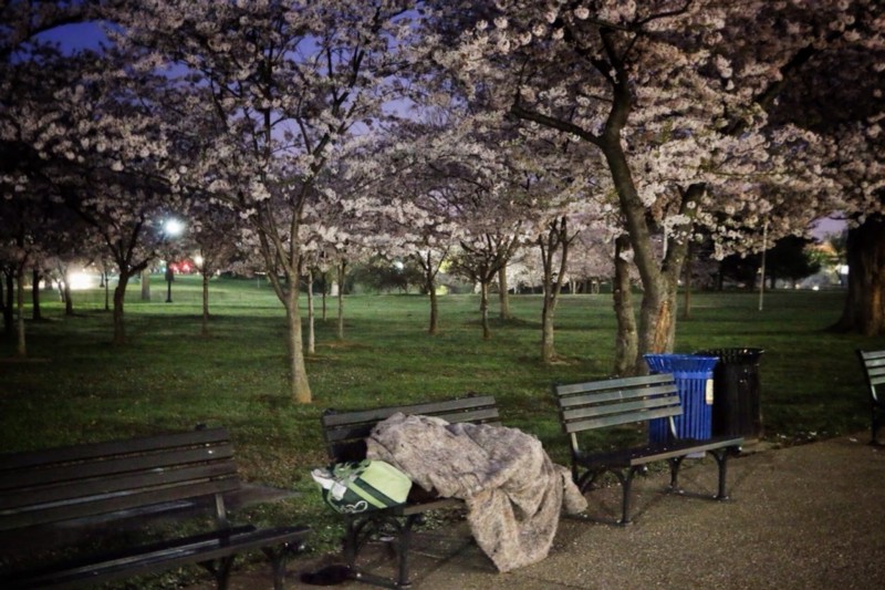 A homeless man rests on a bench in Washington, D.C. CREDIT: SHAWN DAVIS