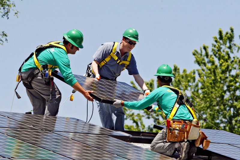 Solar City employees install a solar panel on a home in south Denver. CREDIT: AP PHOTO/ED ANDRIESKI