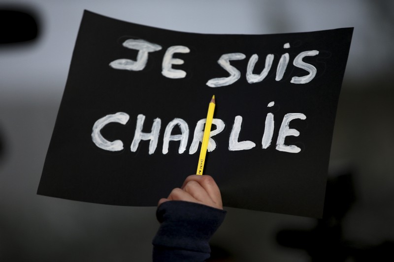 A Lebanese journalist holds up her pen and a placard that reads, “I am Charlie,” as she gathers with other foreign journalists, activists and intellectuals, during a sit-in in downtown Beirut, Lebanon on Sunday. CREDIT: AP