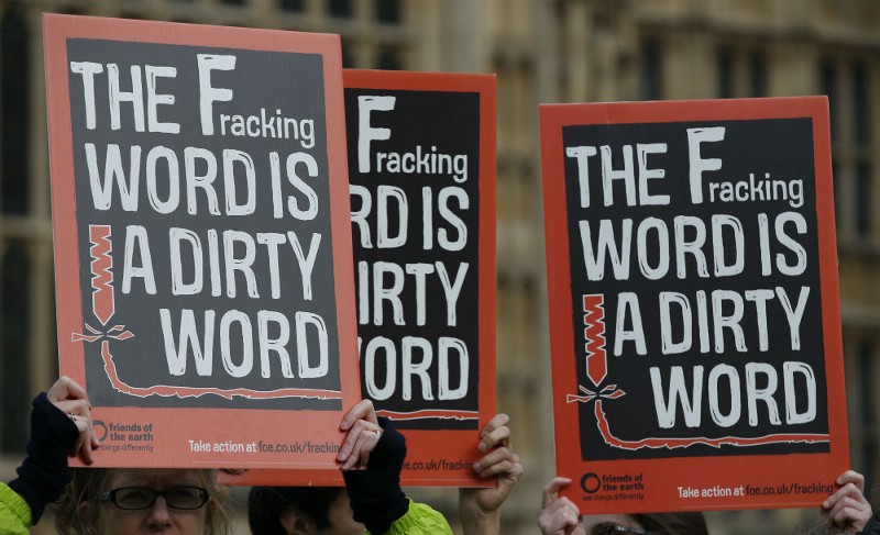 Demonstrators hold up placards as they take part in an anti-fracking protest outside the Palace of Westminster in London, Monday, Jan. 26, 2015. CREDIT: AP PHOTO/ALASTAIR GRANT