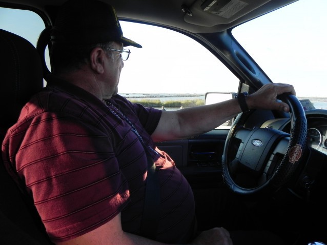 Chief Albert Naquin drives along the narrow and frequently flooded Island Road that connects his tribal community to the mainland. CREDIT: Alice Ollstein