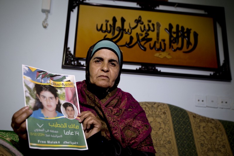 Khawla Al-Khatib, holds a poster of her 14-year-old daughter, Malak al-Khatib, who is serving a two month sentence in an Israeli prison. CREDIT: AP