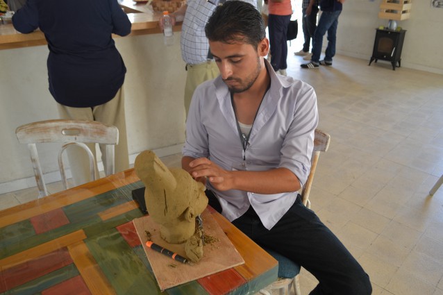 Syrian artist Mahmoud al Hariri works on a sculpture in Za’atatri, a refugee camp in Jordan. CREDIT: International Relief and Development