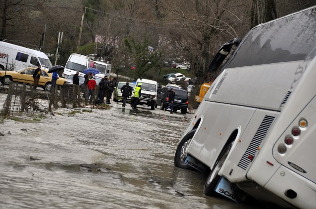 Albanian police and other personnel assist a bus that slid in the water-covered road near Tepelene, 140 kilometers (80 miles) south of capital Tirana, following floods Sunday, Feb. 1, 2015. CREDIT: AP Photo/STR