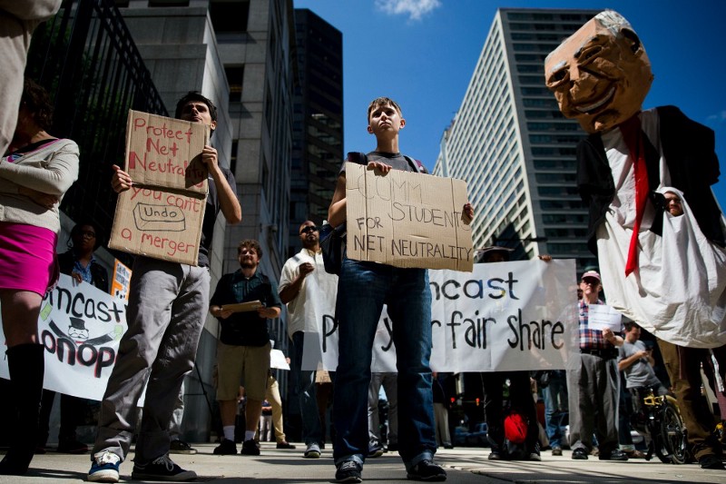 Protesters demonstrate across the street from the Comcast Center Monday, Sept. 15, 2014, in Philadelphia. Demonstrators expressed opposition to the proposed merger of communications companies Comcast Corp. and Time Warner Cable Inc., and called for further Federal Communications Commission (FCC) regulation of Internet traffic to support “net neutrality,” advocates who want strong government protections for the open Internet. CREDIT: AP