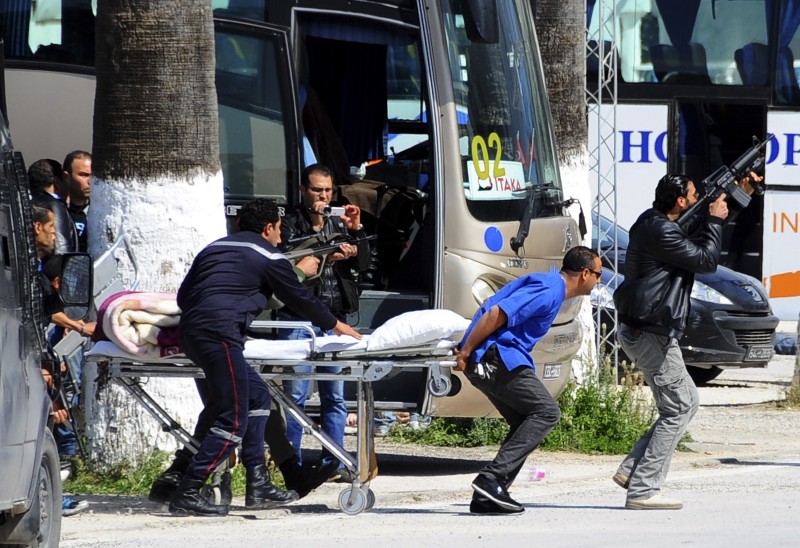 Escorted by security forces, rescue workers pull an empty stretcher outside the Bardo museum Wednesday, March 18, 2015 in Tunis, Tunisia. Authorities say scores of people are dead after an attack on a major museum in the Tunisian capital, and some of the gunmen may have escaped. CREDIT: AP