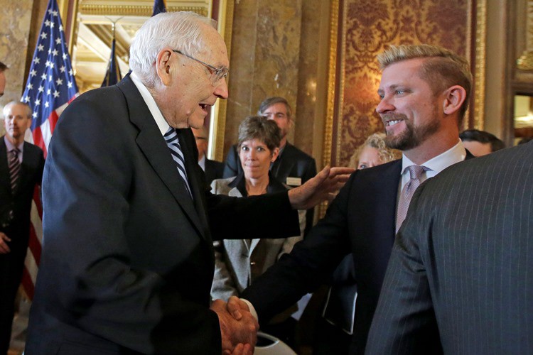 Mormon Elder L. Tom Perry and Equality Utah Executive Director Troy Williams shake hands at a press conference introducing the LGBT nondiscrimination bill. CREDIT: AP PHOTO/RICK BOWMER