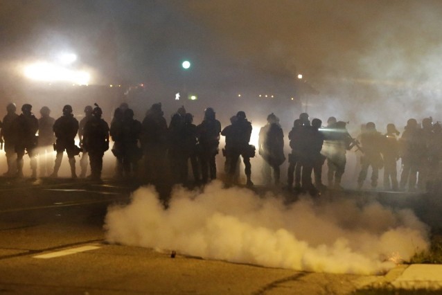 Police advance through smoke in Ferguson, Mo. CREDIT: AP Photo/Jeff Roberson