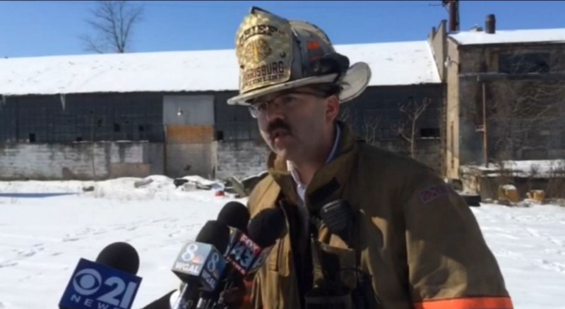Harrisburg Fire Department official addresses media at scene of warehouse fire on Monday that may have stemmed from homeless people’s efforts to keep warm. CREDIT: PENNLIVE