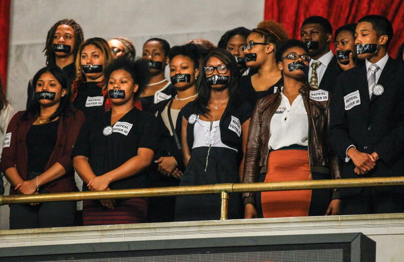 Members of the Nashville Student Organizing Committee stage a silent protest in the gallery of the House chamber in Nashville, Tenn., Monday, March 24, 2014. The group opposes a state law that prevents student IDs to be used to vote in Tennessee. CREDIT: AP PHOTO/ERIK SCHELZIG