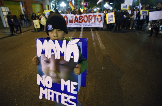 A boy wears a sign that reads in Spanish: “Mama, don’t kill me” during an anti-abortion protest in Bolivia CREDIT: AP Photo/Juan Karita