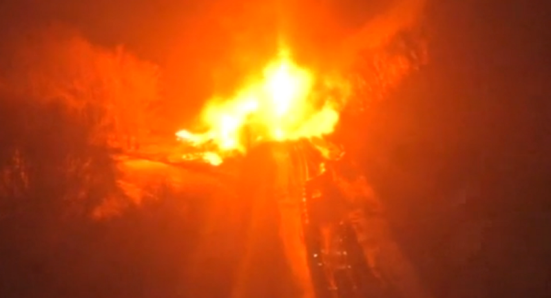 The damaged railcars were still burning on Thursday night. CREDIT: KCRG SCREENSHOT