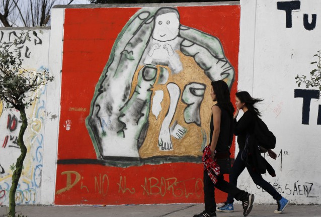 A young couple walks before a pro-life mural in Quito, Ecuador that reads in Spanish: “Say no to abortion” CREDIT: AP Photo/Dolores Ochoa