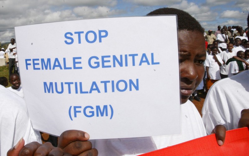 A girl holds a protest sign during the anti-Female Genital Mutilation (FGM) run in Kilgoris, Kenya, April 21, 2007. CREDIT: AP