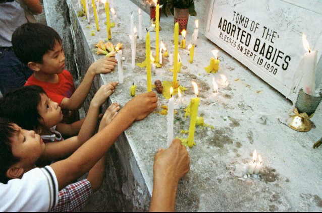 Children of anti-abortion activists light candles for aborted babies in the Philippines CREDIT: AP Photo/Bullit Marquez