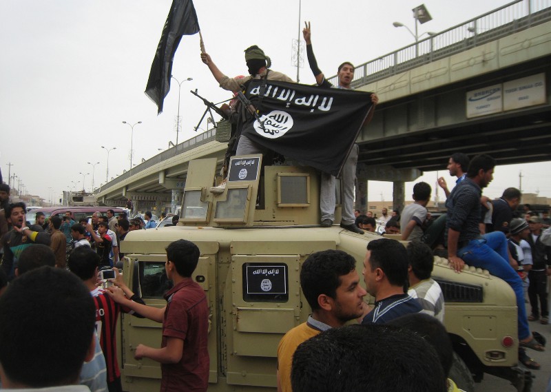 In this Sunday, March 30, 2014, file photo, Islamic State group militants hold up their flag as they patrol in a commandeered Iraqi military vehicle in Fallujah, 40 miles (65 kilometers) west of Baghdad, Iraq. Abu Bakr al-Baghdadis forces swept into Ramadi and Fallujah in Iraqs Anbar province, which Iraqi security forces had abandoned weeks earlier. That came after security forces killed demonstrators during a Sunni protest, effectively turning the unrest into an uprising. CREDIT: AP