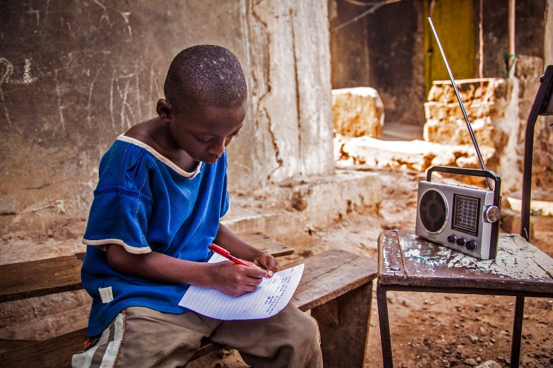 A boy in Freetown, Sierra Leone listened to school classes broadcast over the radio on Feb. 2015. Schools across the country have been closed in an effort to prevent the spread of the virus. CREDIT: AP