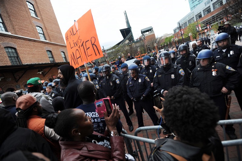 Protesters rally against the death of Freddie Gray outside Oriole Park at Camden Yards in Baltimore. CREDIT: (AP PHOTO/GAIL BURTON)