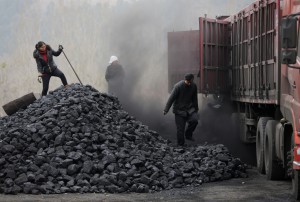 Workers load coal into a truck in Beijing CREDIT: AP