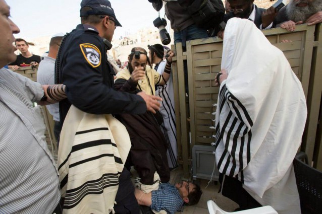 Police officers, WOW supporters, and ultra-Orthodox men scuffle at the fence dividing the genders. CREDIT: Miriam Alster / Flash 90