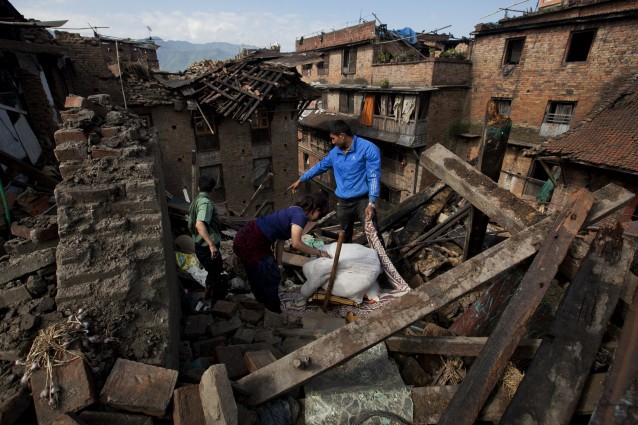 A Nepalese family collects belongings from their home destroyed in Saturday’s earthquake, in Bhaktapur on the outskirts of Kathmandu, Nepal, Monday, April 27, 2015.