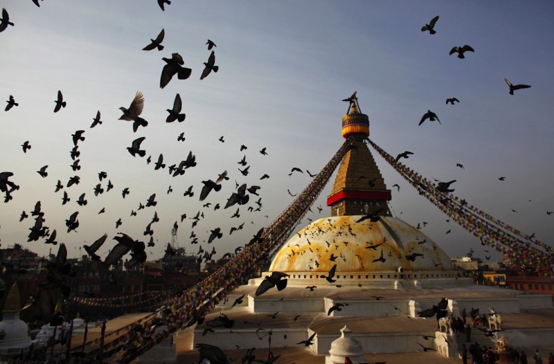 Pigeons fly around Boudhanath Stupa, a world heritage site, as devotees perform rituals on the last day of Tibetan Losar, or New Year, in Kathmandu, Nepal, in March 2014.