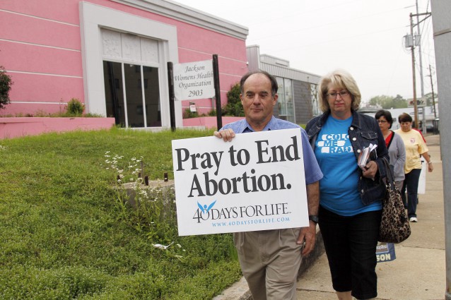Rev. Doug Lane leads a group of abortion opponents past the Jackson Women’s Health Organization clinic CREDIT: AP Photo/Rogelio V. Solis