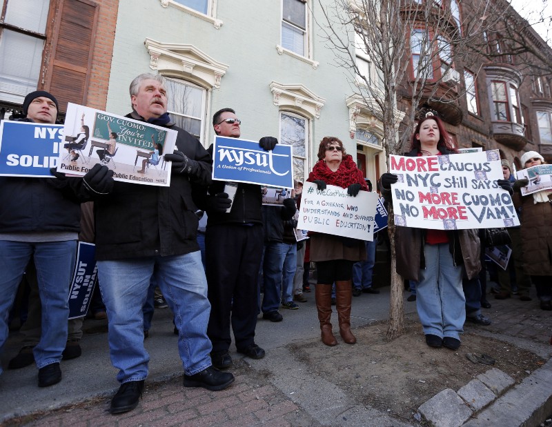 Members of New York State United Teachers rally across the street from the Executive Mansion as New York Gov. Andrew Cuomo hosts an open house in Albany, N.Y. CREDIT: AP PHOTO/MIKE GROLL