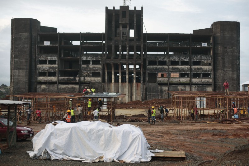 Construction workers build an Ebola isolation and treatment center in front of an unfinished and abandoned government building in Monrovia, Liberia CREDIT: AP PHOTO/JEROME DELAY
