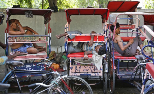 Indian rickshaw pullers sleep in their rickshaws on a hot summer day in New Delhi, India, Thursday, May 21, 2015. CREDIT: AP Photo/Manish Swarup
